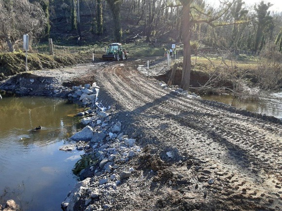 Image A tractor restores the material forming a creek crossing