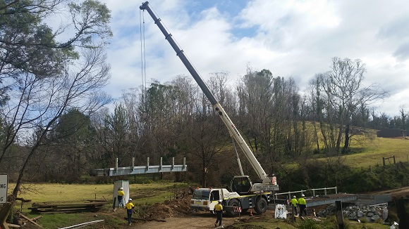 Image A crane lifts a section of bridge