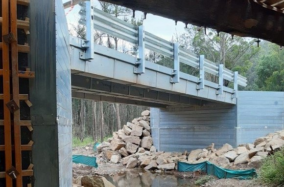 Image A new bridge sits high above a creek