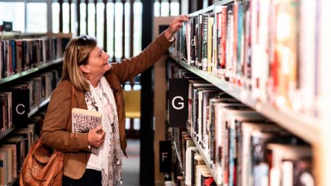 Woman browsing library books.