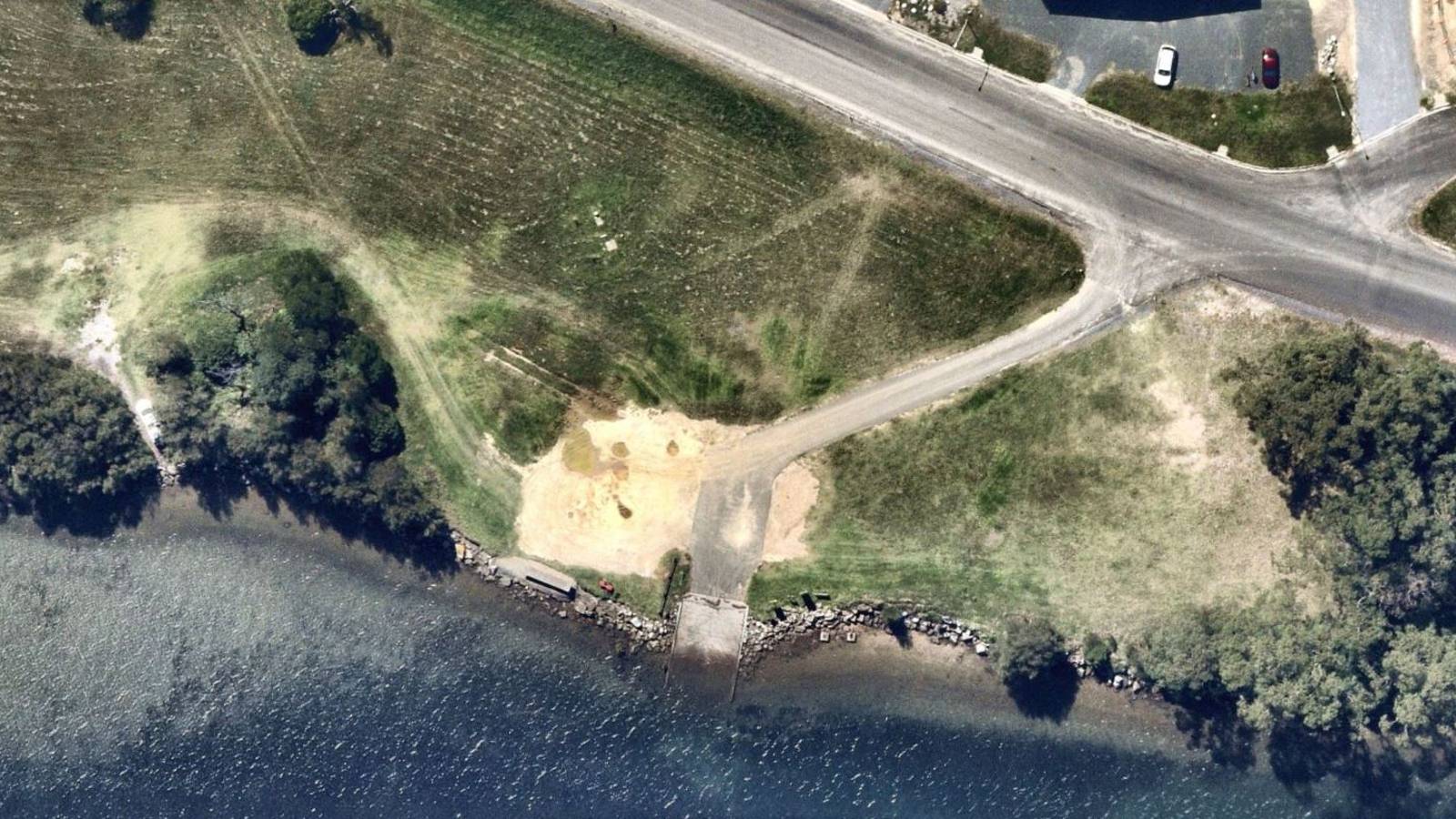 Image An aerila image shows a boat ramp leading into a river from a grassed area with a dirt car park.