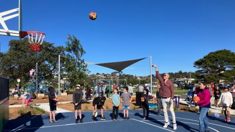 Kids and adults playing basketball