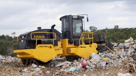 A compactor rolling over rubbish