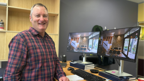 man smiling in front of computer 