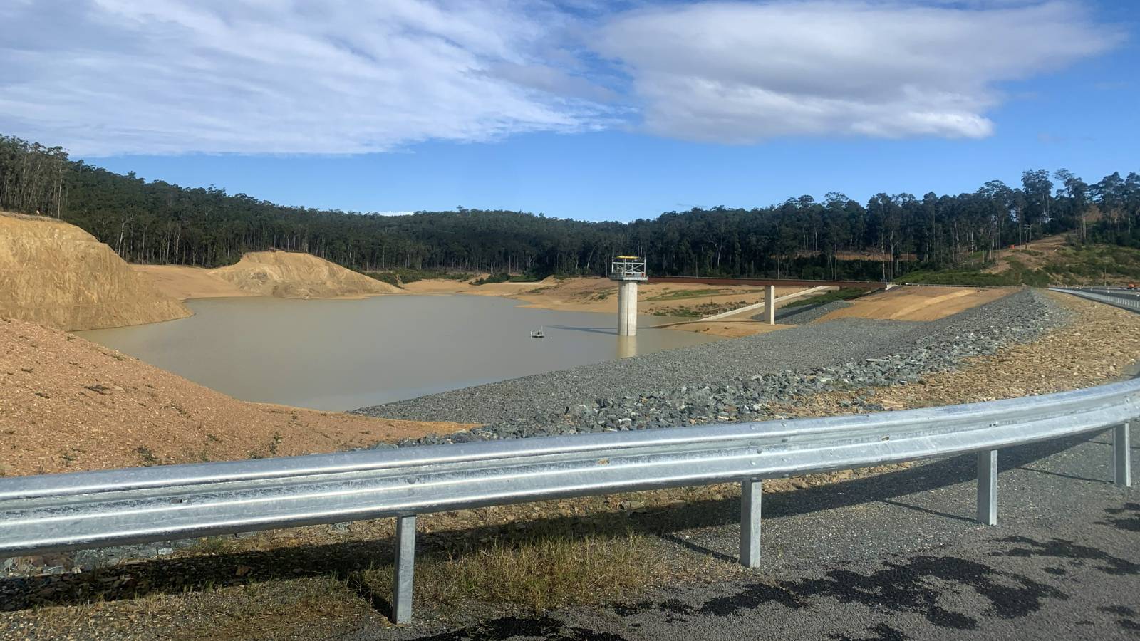 Water sits at the bottom of a water storage facilities in a forest setting.