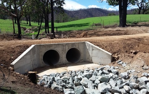 Image A dirt road passes over concrete pipes where the timber bridge once sat