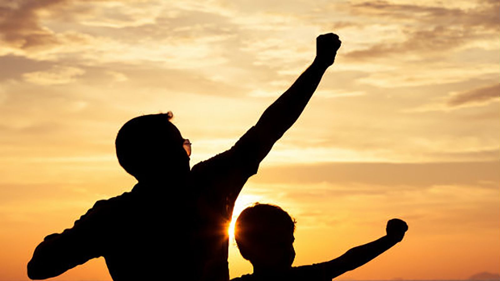 Silhouettes of a man and child with one arm raised into the air banner image