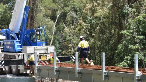Male worker walking across a concrete bridge under construction