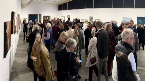 a crowd of people in a gallery room