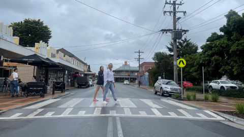 Two females walking over a raised pedestrian crossing 