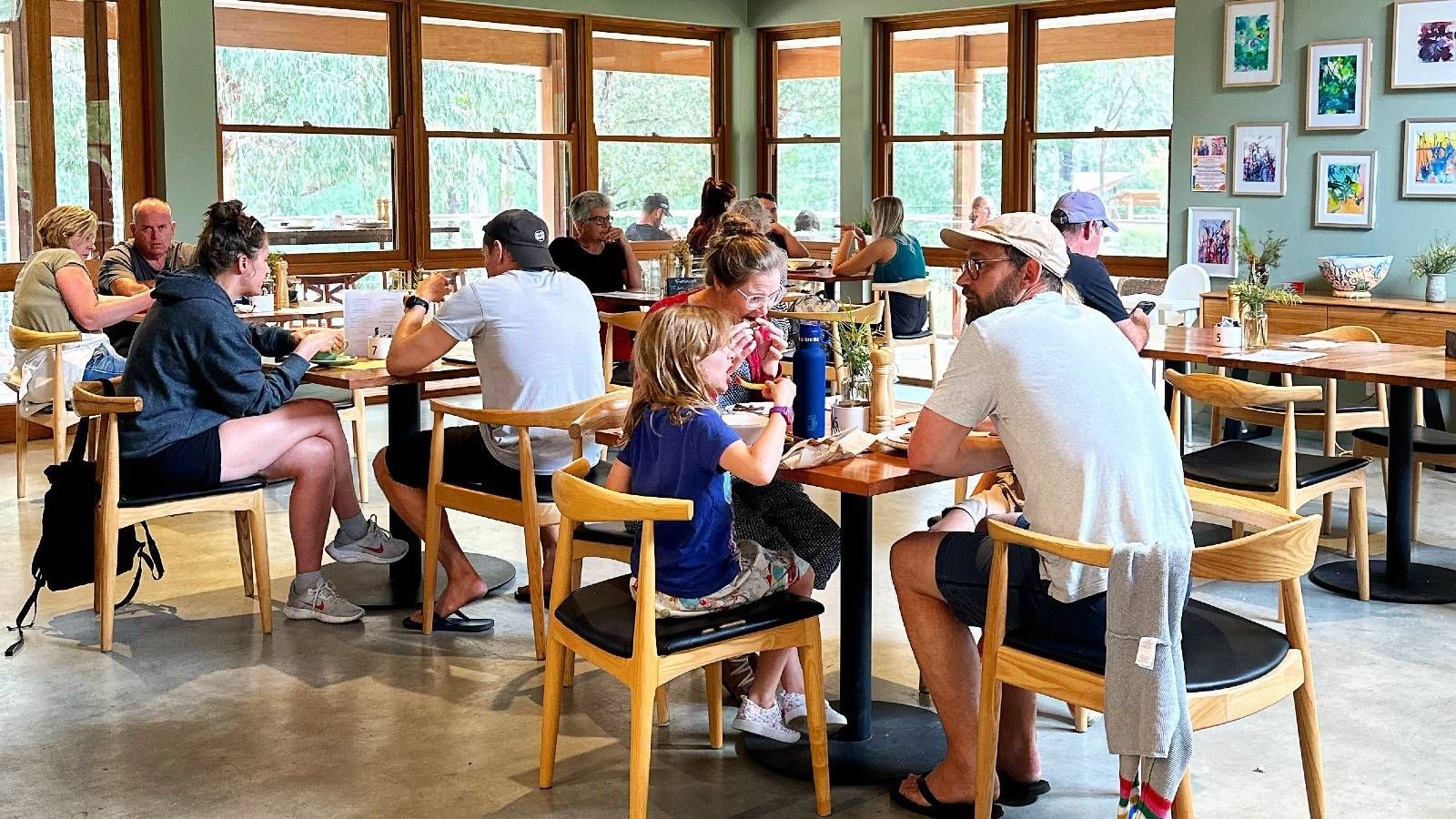People sitting at tables and chairs eating and talking banner image