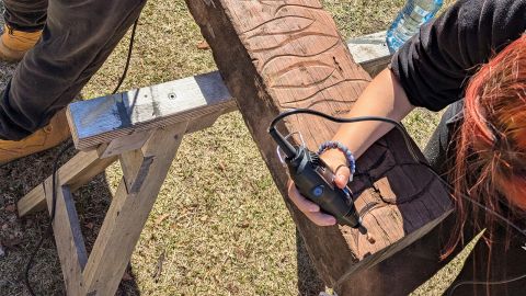 A person creating decorations on wood