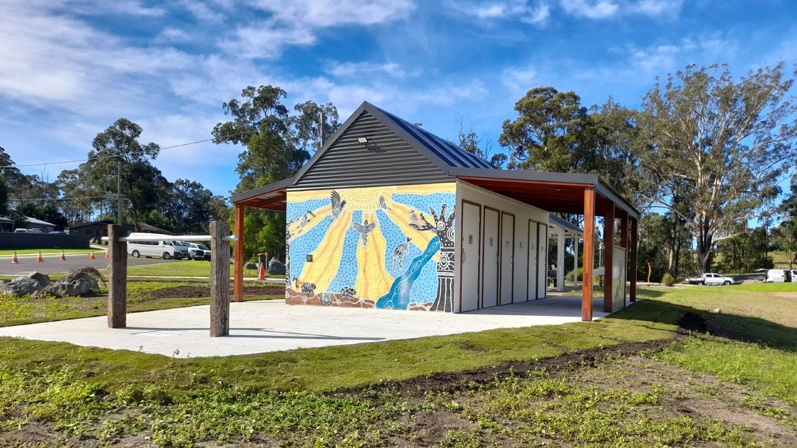 Image Public toilet block covered in Aboriginal artwork adjacent to a mountain bike wash site.