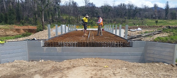 Image Two men inspect the steel reo mesh supported by aluminum abutments