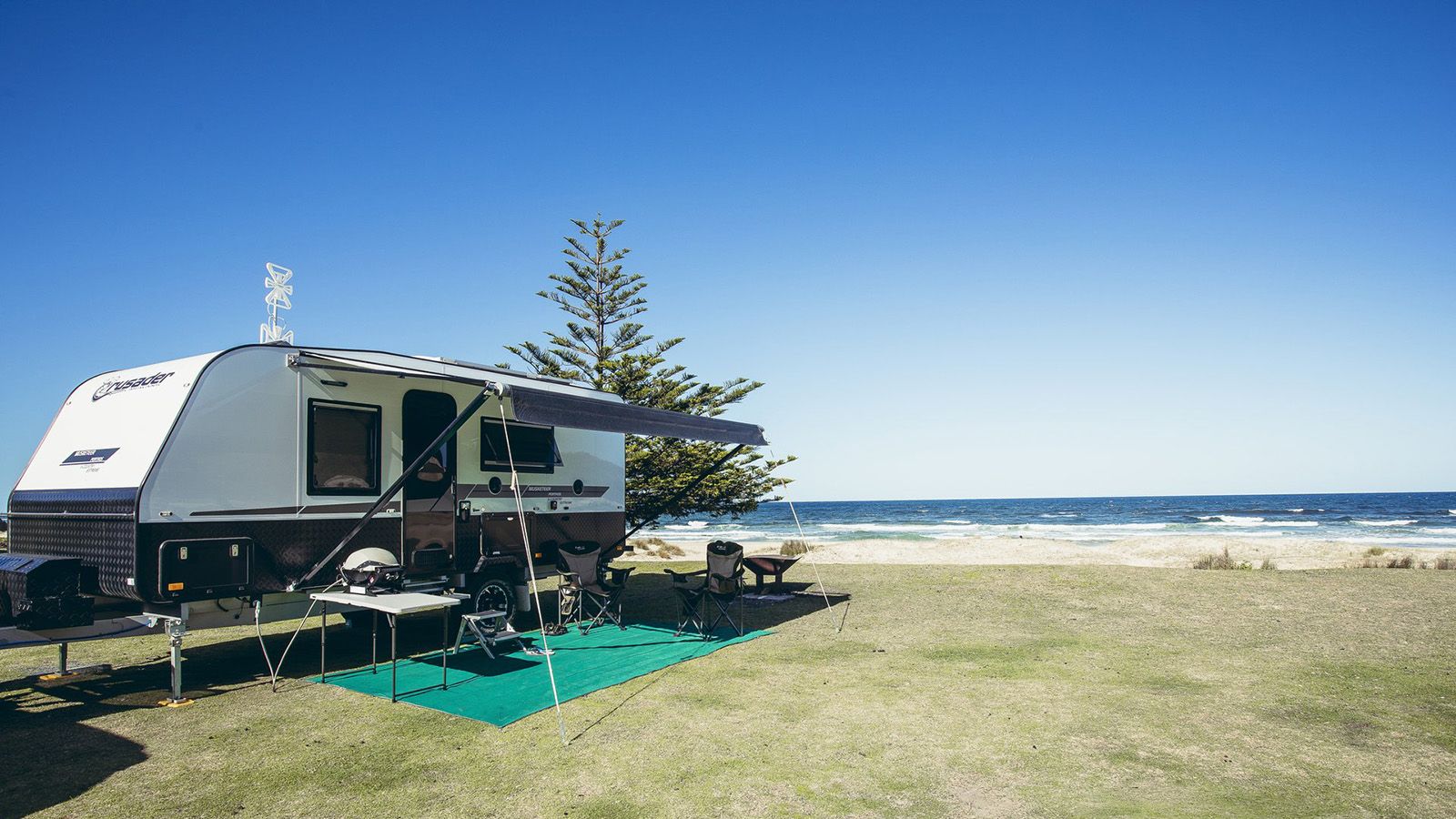 A caravan at a beachside camping ground banner image