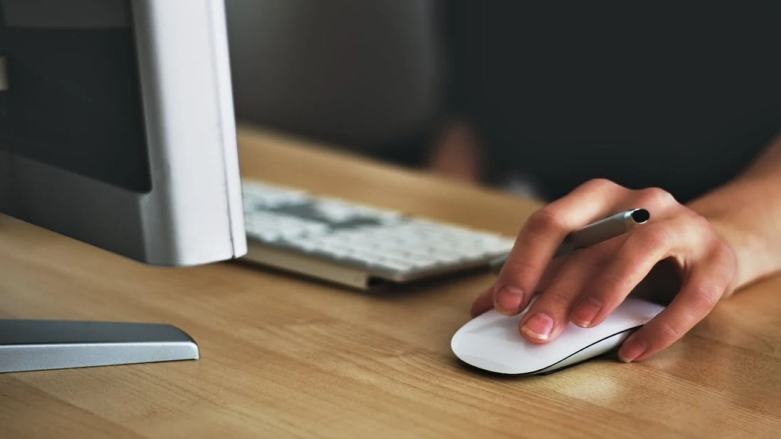 A person using a laptop computer holding a mouse banner image