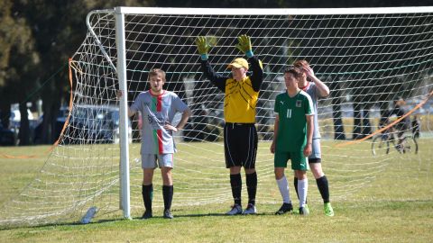 Football players standing in a goal net 