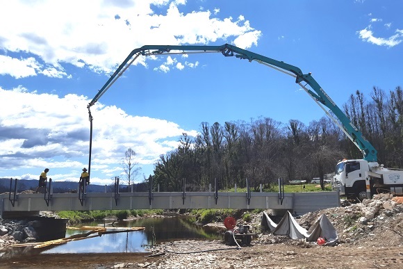 Image A concrete boom pumps concrete into place to form the new bridge deck