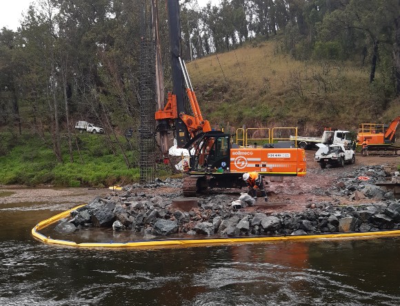 Image Heavy machinery sits in a construction site alongside a creek