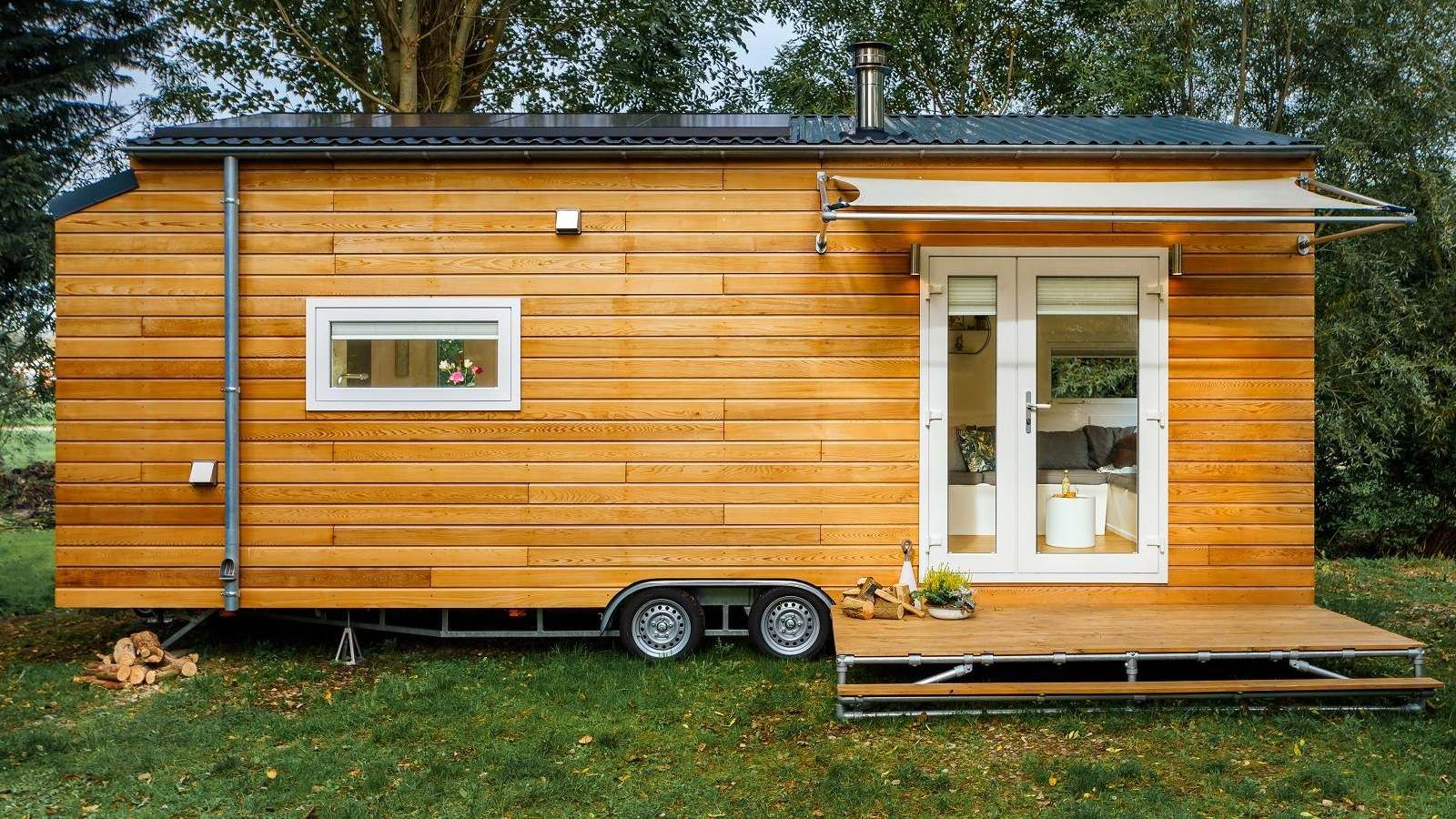 Tiny timber home on a trailer in a backyard banner image