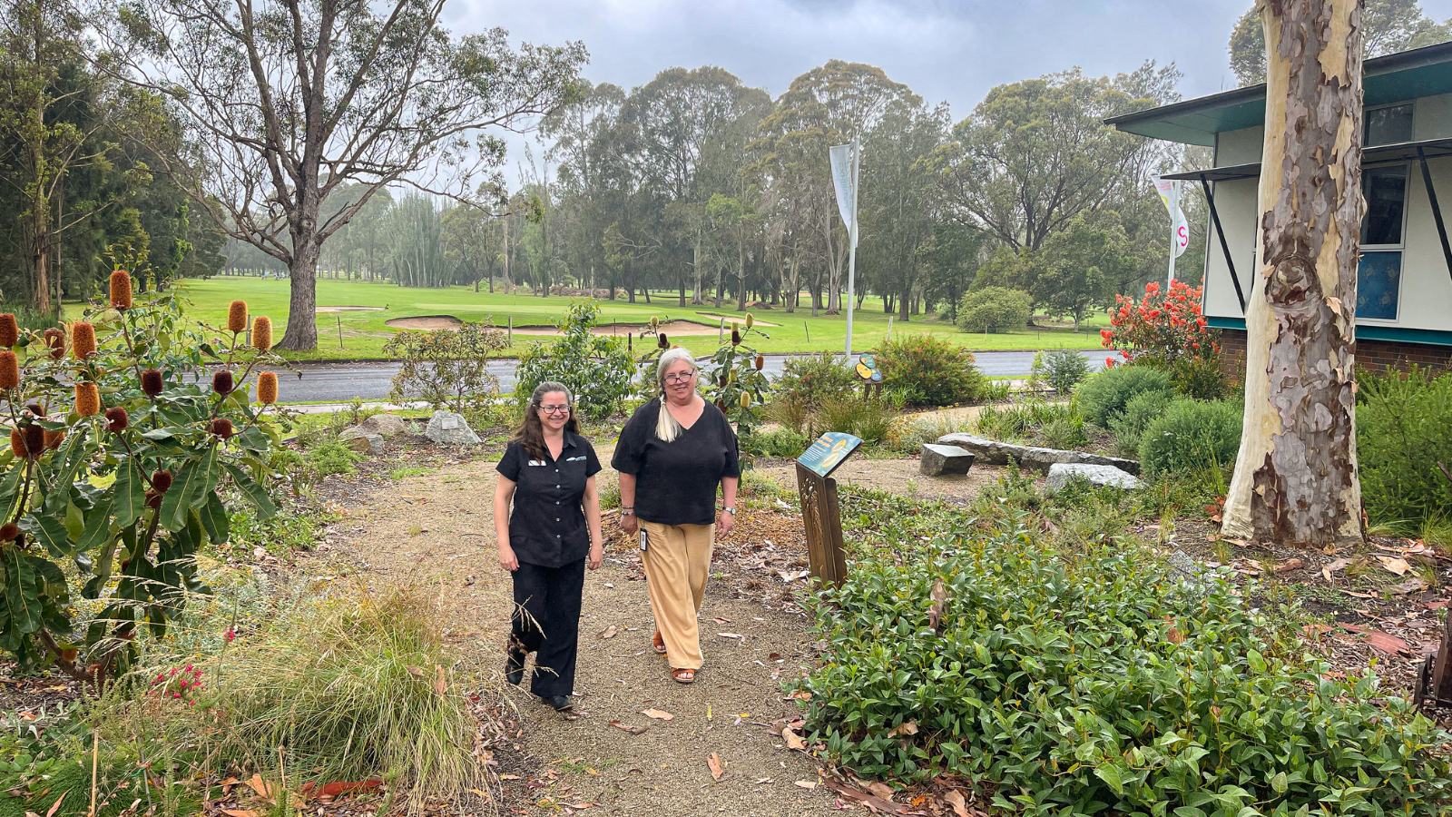 Image Two people walking through a garden