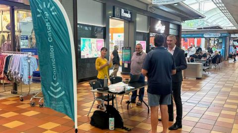 people standing around a table in a shopping centre