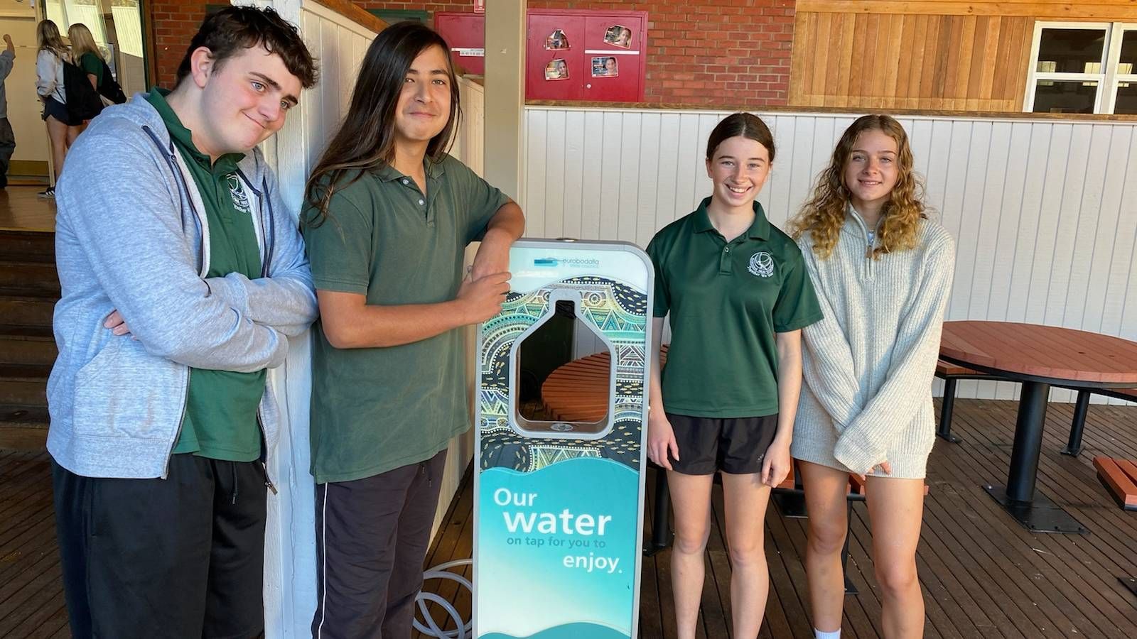 Four high school students standing next to a Council water dispenser banner image