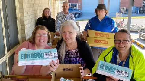 Staff from Yumaro holding boxes of the residents' newsletter, Living in Eurobodalla