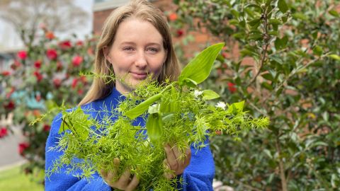 Woman holds bunch of weeds 