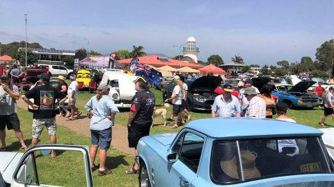 people and cars crowded on an oval