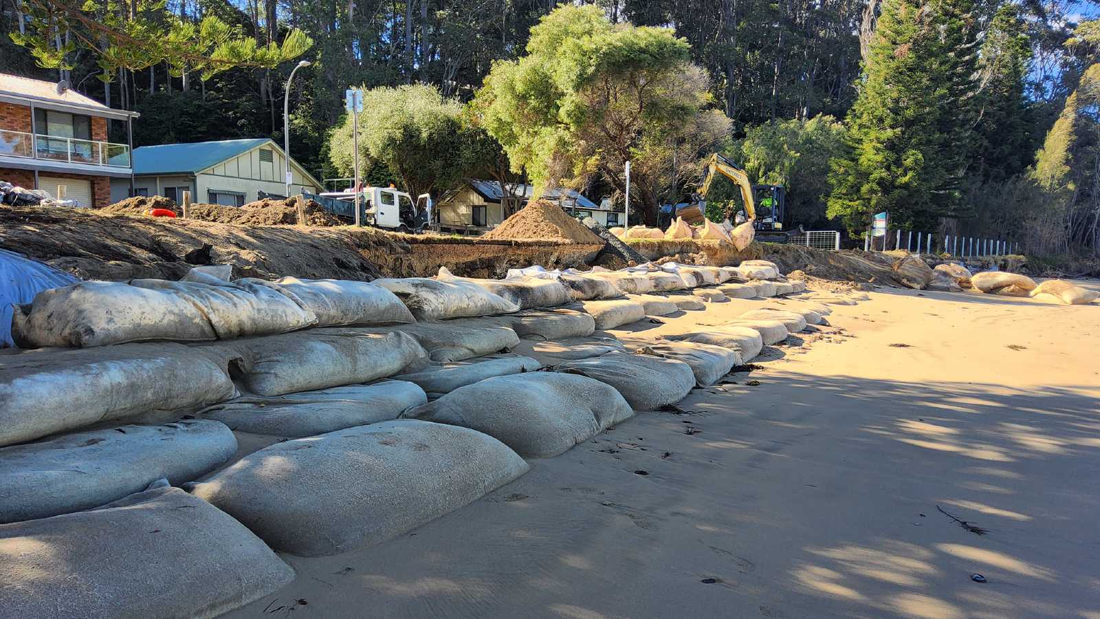 Image Large sandbags are arranged in tiers along a beach impacted by coastal erosion.