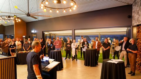 A large group of people listening to a speaker 