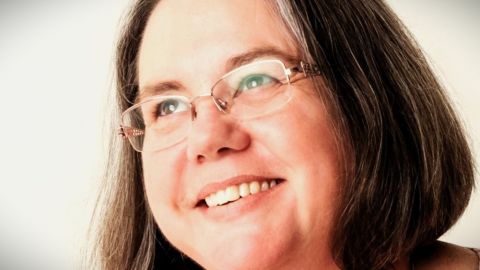 Close up of face of grey-haired lady wearing glasses