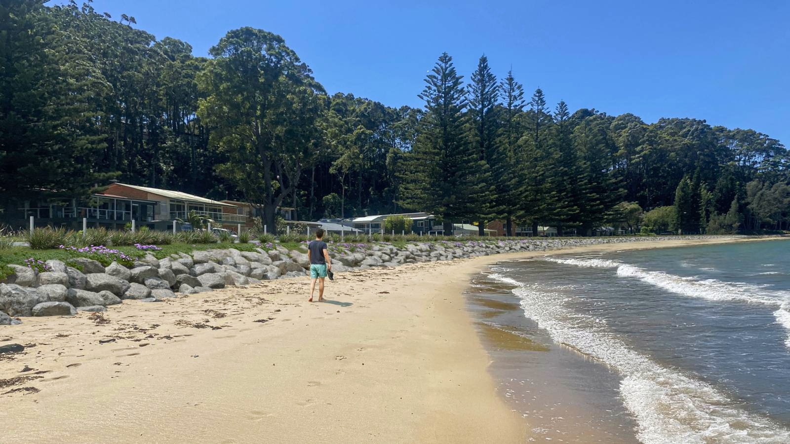 A visualisation shows a person walking along the beach next to a rock revetment.