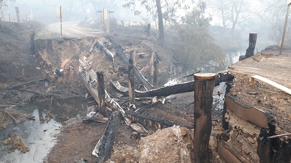 Image All the bridge timbers are burnt and have collapsed