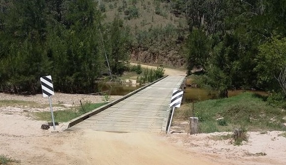 Image The long timber bridge crosses the Tuross River in a lush setting