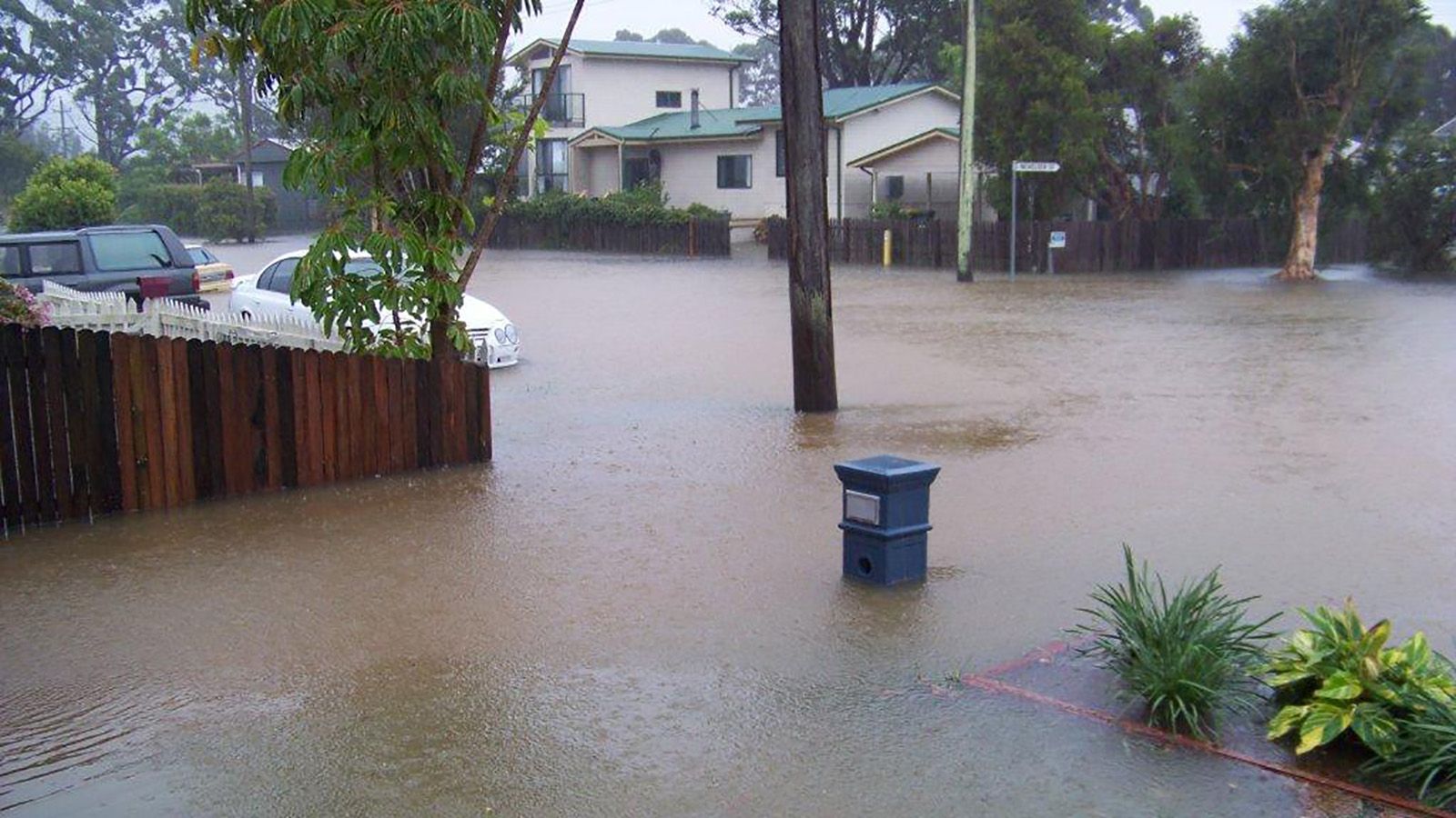 A residential street flooded with storm water banner image