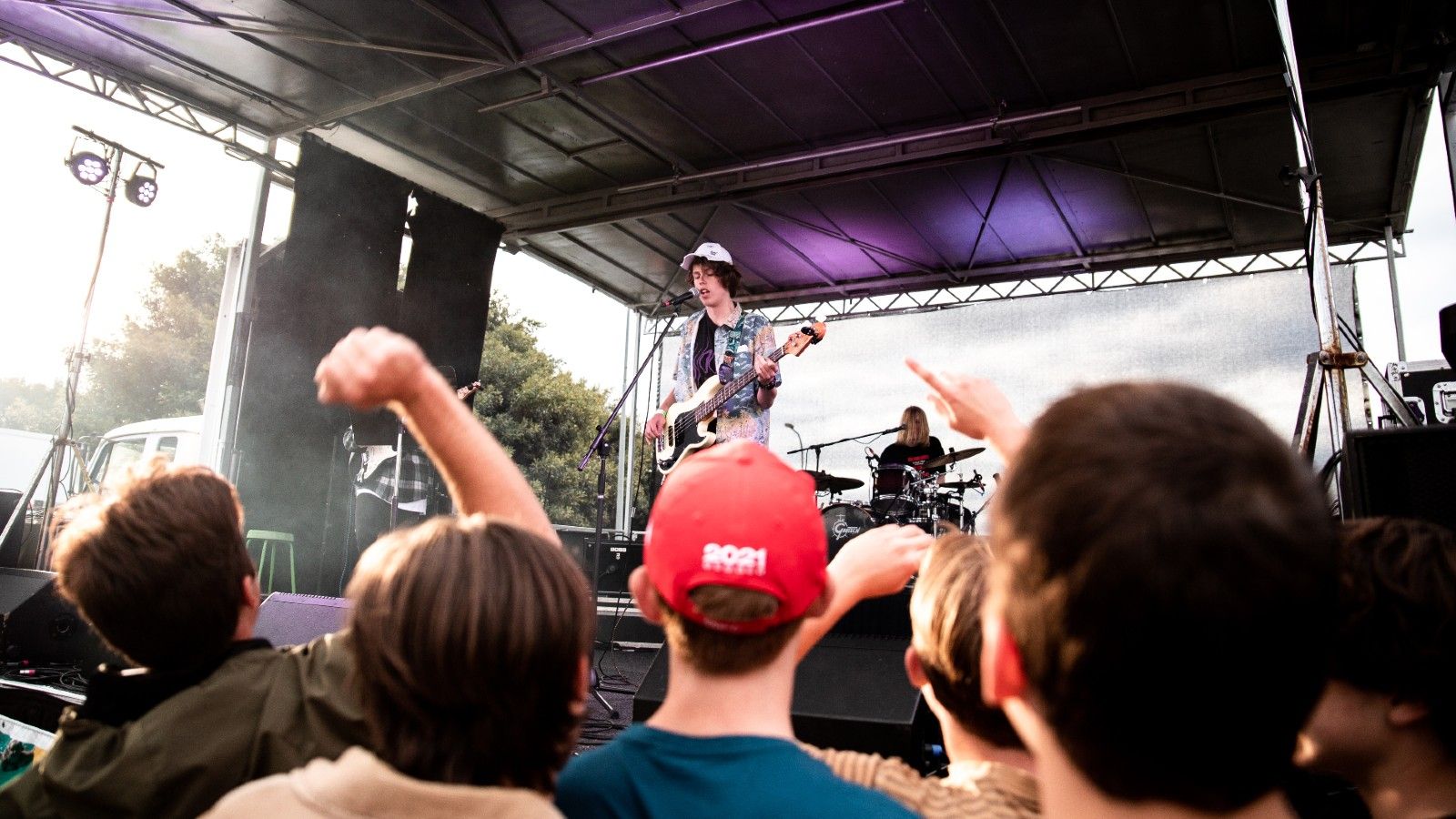 Young people seated picnic style at an outdoor event banner image