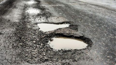 Section of tarmac road with large pothole