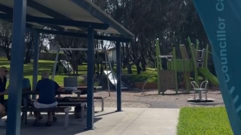 people sitting at  a park bench and table