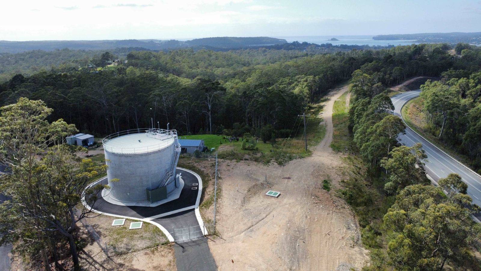 A reservoir overlooking bushland and the ocean banner image