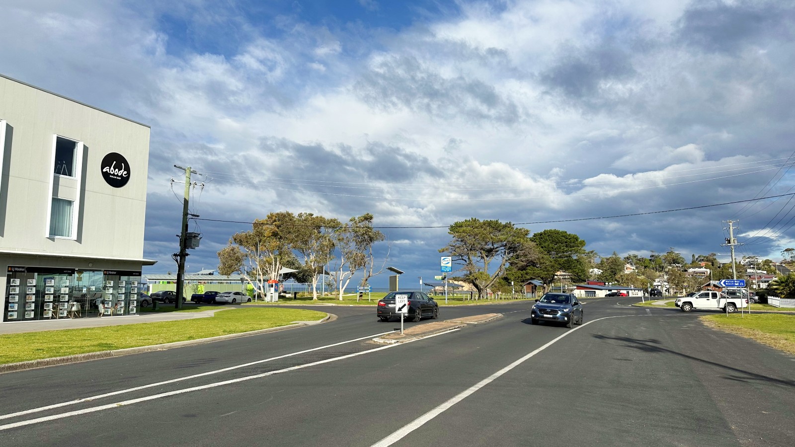 Image Vehicles pass through an intersection with a park in the background