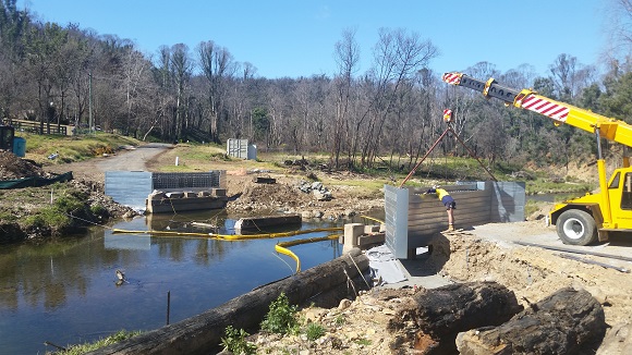 Image A mobile crane lowers a steel bridge abutment into place.