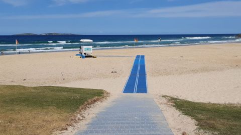 long blue mat on sand at beach