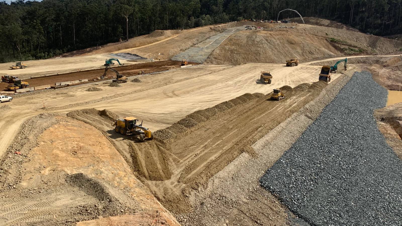 Large scale earthworks are in progress with trees in the background.