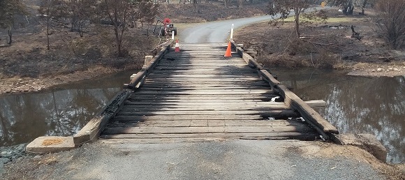 Image THe timber bridge is largely burnt along each side