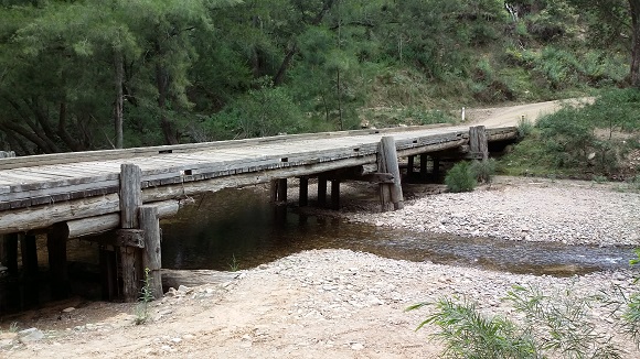 Image A mulit-span timber bridge passes over a wide riverbed