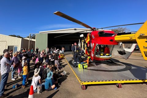 A crowd of adults and children by a helicopter