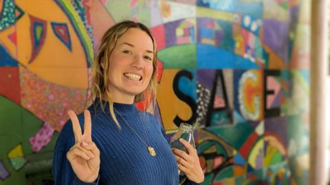 woman standing in front of a bright coloured wall