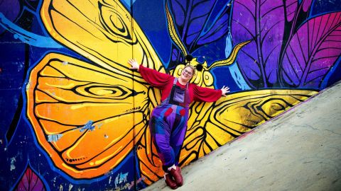 A woman wearing a large, colourful butterfly costume.